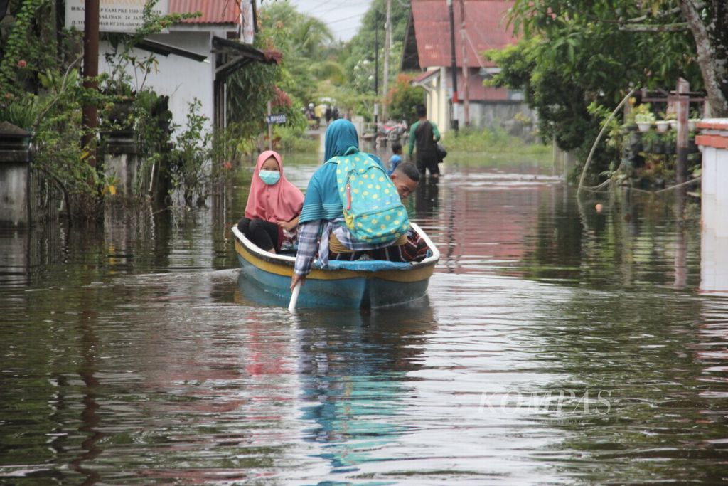 Warga Kecamatan Sintang, Kabupaten Sintang, Kalimantan Barat, mengarungi banjir menggunakan perahu, Sabtu (30/10/2021). Ketinggian banjir di daerah tersebut berkisar 50 sentimeter-1 meter. 