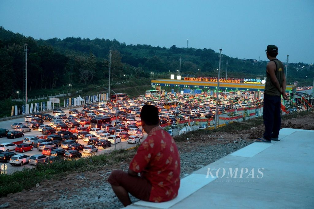 Warga melihat antrean panjang kendaraan roda empat saat puncak arus mudik yang memadati Gerbang Tol Kalikangkung di Kota Semarang, Jawa Tengah, Sabtu (1/6/2019). Mereka mulai menuju sejumlah wilayah Jawa Tengah dan Jawa Timur melalui jalan Tol Trans Jawa yang pada tahun ini telah difungsikan secara keseluruhan. Rekayasa lalu-lintas untuk mengurai kepadatan lalu-lintas terus dilakukan agar pemudik dapat melaluinya dengan nyaman dan aman.
