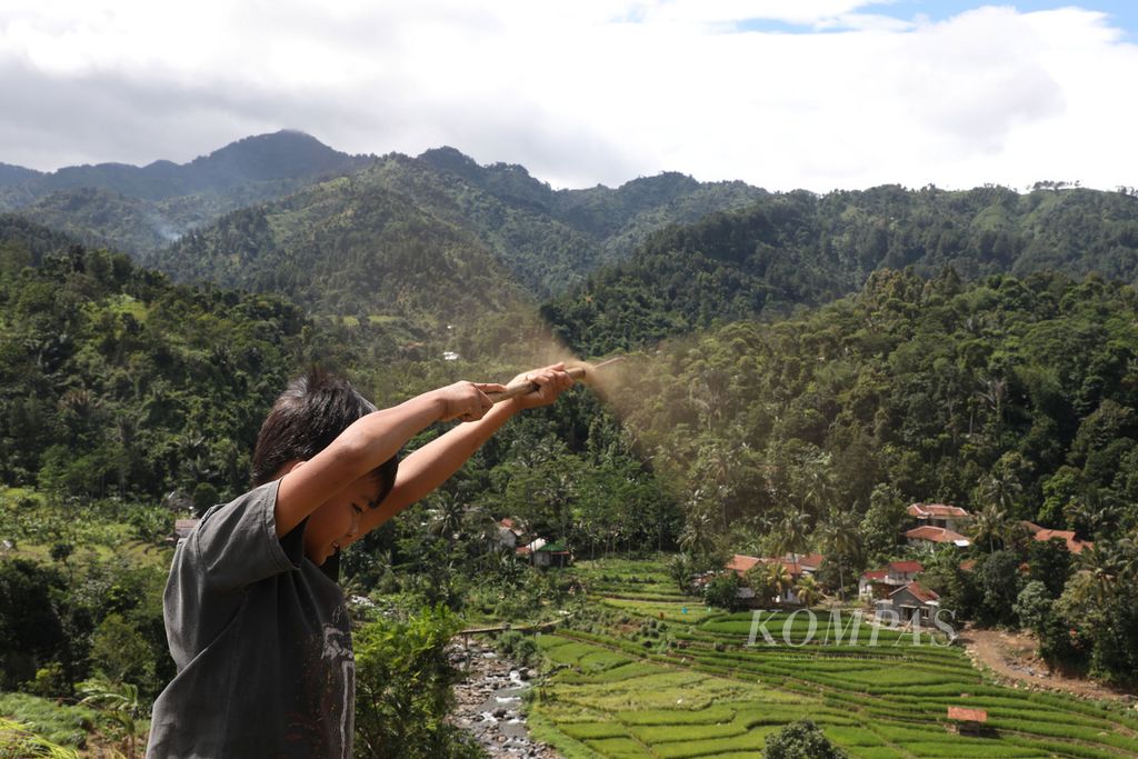 Seorang anak bermain baling-baling dari bambu di puncak bukit di Desa Karangtengah, Kecamatan Babakan Madang, Kabupaten Bogor, Jawa Barat, beberapa waktu lalu.