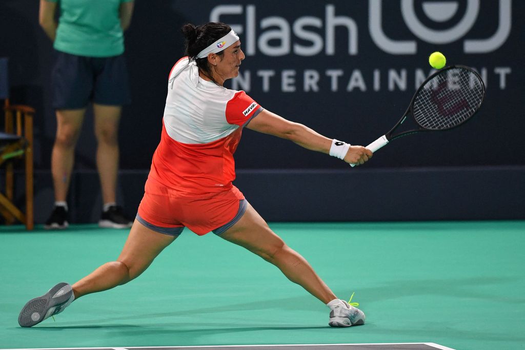 Petenis Tunisia, Ons Jabeur, memukul bola saat melawan petenis Inggris, Emma Raducanu, dalam laga Kejuaraan Tenis Dunia Mubadala di Abu Dhabi International Tennis Complex, Uni Emirat Arab, Sabtu (17/12/2022) dini hari WIB. Jabeur menang dengan skor 5-7, 6-3, 10-8. 