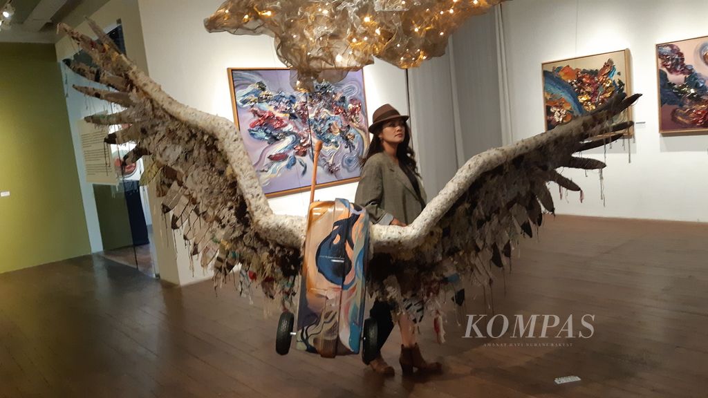 Inanike Agusta dengan karya patung koper bersayap, ”Bound for the Infinite”, dalam pameran tunggal bertajuk Wings of Time di D’Gallerie, Jakarta, Senin (25/11/2024). Pameran diselenggarakan mulai dari 24 November hingga 14 Desember 2024.