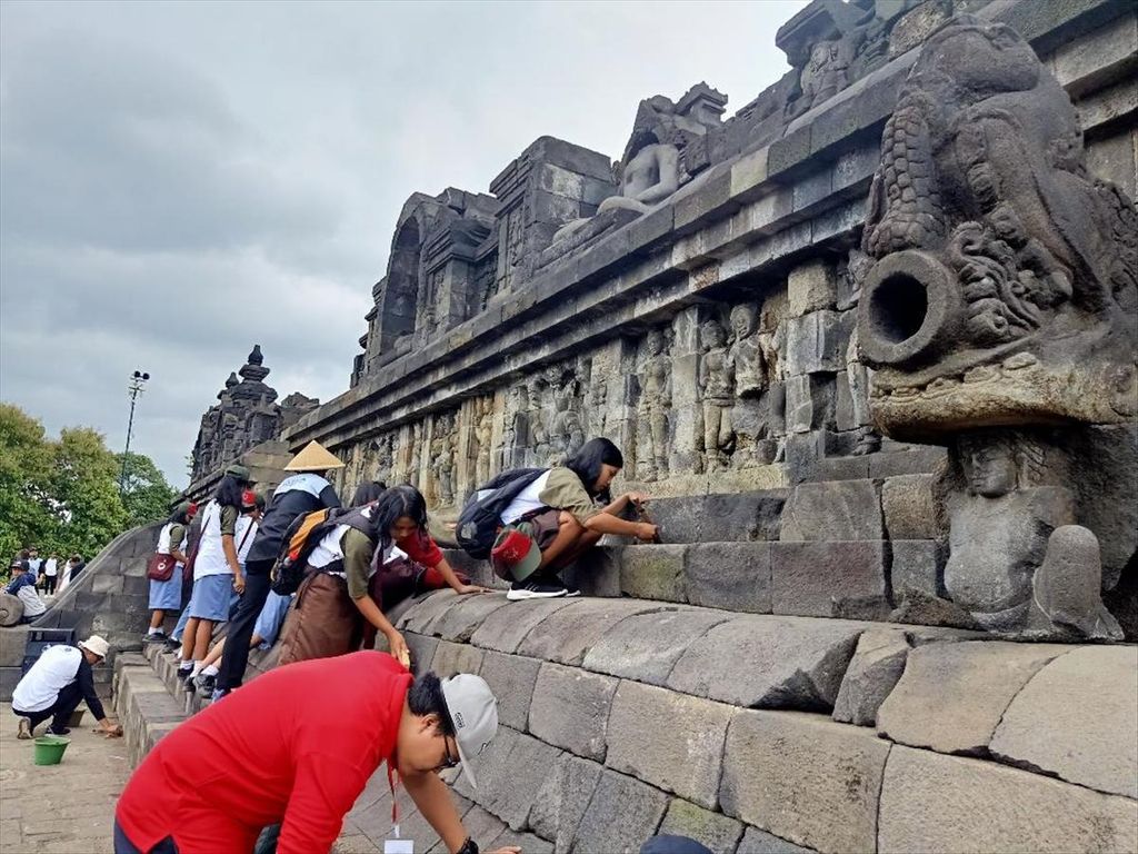 Sejumlah siswa SMK, sukarelawan, dan petugas kebersihan dari Balai Konservasi Borobudur bersama-sama membersihkan kerak dan lumut yang ada di bangunan Candi Borobudur, Kabupaten Magelang, Jawa Tengah, Jumat (14/6/2019).