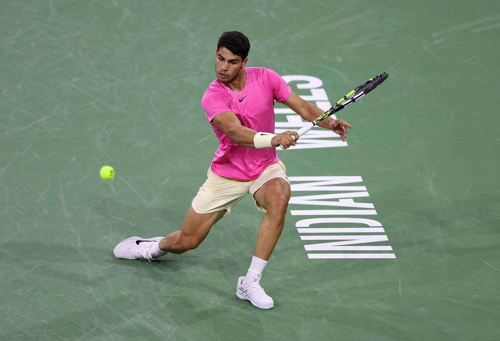 Petenis Spanyol Carlos Alcaraz mengembalikan bola ke petenis Inggris Jack Draper dalam laga ATP Masters 1000 Indian Wells di Indian Wells, California, Selasa (14/3/2023). Draper menyerah karena cedera pada laga itu.