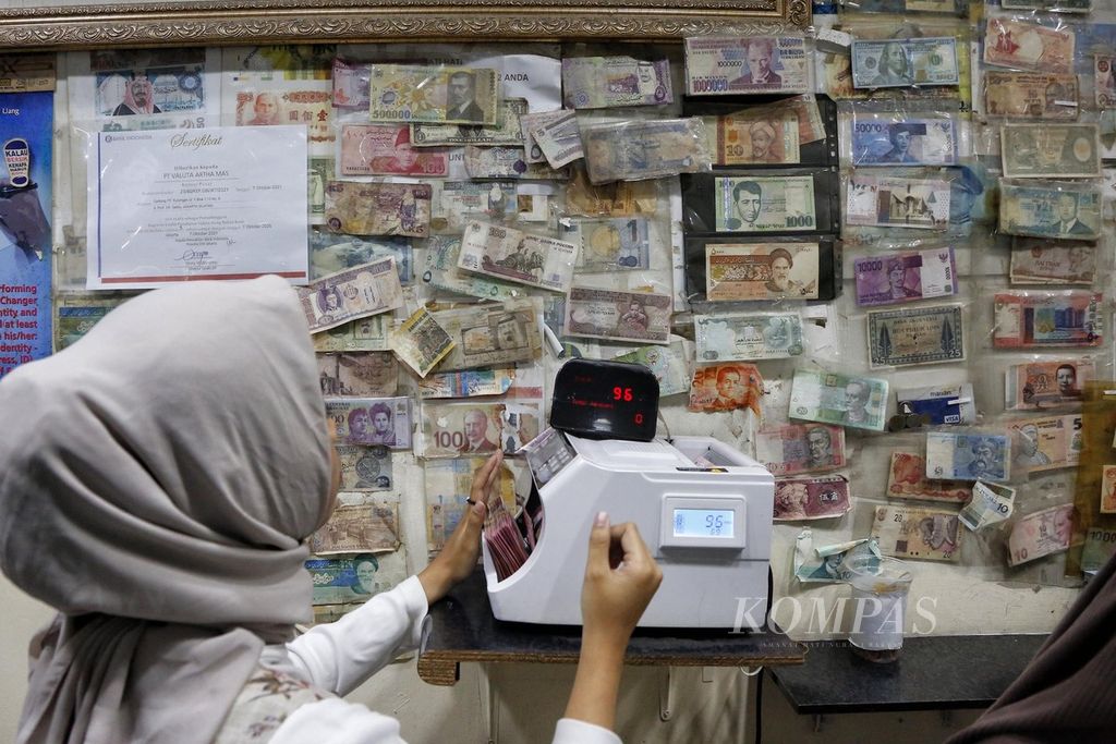 Berbagai mata uang asing ditempel di dinding tempat penukaran valuta asing PT Valuta Artha Mas, ITC Kuningan, Jakarta, Jumat (10/3/2023).
