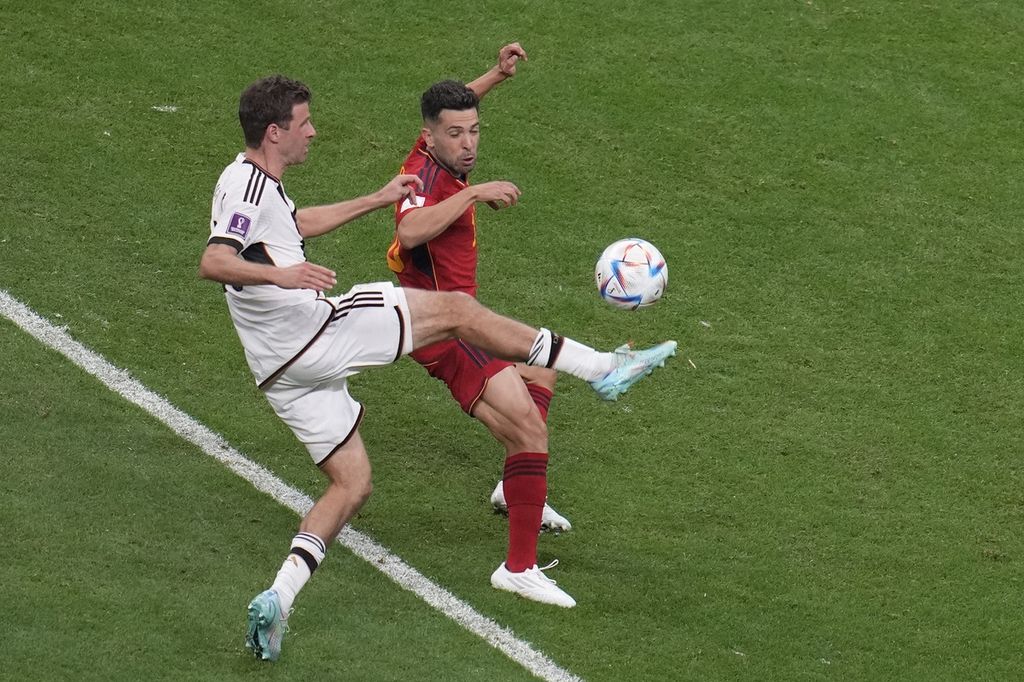 Pemain timnas Jerman Thomas Mueller (kiri) berebut bola dengan pemain timnas Spanyol Jordi Alba dalam laga penyisihan Grup E Piala Dunia Qatar 2022 di Al Bayt Stadium, Al Khor, Qatar, Minggu (27/11/2022). Laga berakhir imbang 1-1. 