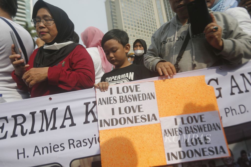 Warga menunggu kedatangan Gubernur DKI Jakarta Anies Baswedan sambil membawa poster dukungan terhadap Anies saat hari bebas kendaraan bermotor di kawasan Bundaran Hotel Indonesia, Jakarta, Minggu (16/10/2022). Anies bersepeda dari rumahnya di kawasan Lebak Bulus menuju Balaikota DKI Jakarta untuk berpamitan kepada warga Jakarta di hari terakhir menjabat sebagai Gubernur DKI Jakarta.