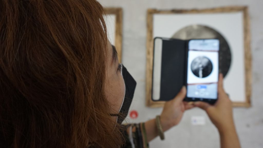 Artis visual Bernadette Godeliva Fabiola Natasha alias Kaze Kazumi memperlihatkan satu dari lima karya foto yang sedang dipamerkan di Visma Art Gallery, Surabaya, Jawa Timur, dan bisa dinikmati secara <i>augmented reality </i>(AR) melalui pemindaian pada aplikasi. Pameran fotografi bertema Puja berlangsung 11 Maret-11 April 2022. Selain pameran juga diluncurkan buku fotografi yang memuat 26 karya dan 8 haiku atau puisi bait gaya Jepang kuno.
