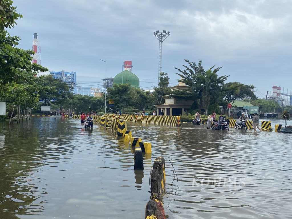 Para pekerja mendorong kendaraannya keluar dari kawasan Pelabuhan Tanjung Emas, Kota Semarang, Jawa Tengah, Rabu (26/5/2022). Ribuan kendaraan pekerja di kawasan itu terendam rob selama beberapa hari lantaran ditinggal pemiliknya menyelamatkan diri saat tanggul laut di kawasan itu jebol pada Senin (23/5/2022). Kendaraan-kendaraan itu langsung dibawa ke bengkel untuk diperbaiki setelah terendam rob setinggi 1,5 meter.