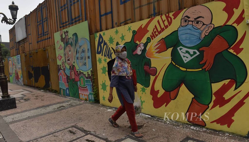 Warga melintas di depan mural bertema protokol kesehatan di Jalan Tunjungan, Kota Surabaya, Jawa Timur, Senin (21/2/2022). Mural yang sejatinya untuk mengingatkan warga agar patuh pada protokol kesehatan banyak dirusak oleh tangan yang tidak bertanggung jawab. 