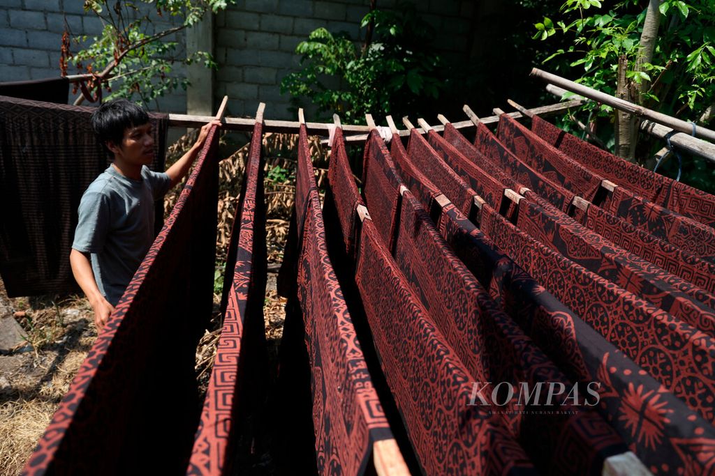 Aktivitas penjemuran kain sarung yang menjadi industri rumahan di Kampung Kertoharjo, Kecamatan Pekalongan Selatan, Kota Pekalongan, Jawa Tengah, Selasa (23/5/2023). Setelah beberapa waktu terdampak pandemi sentra kerajinan batik di Pekalongan kembali berangsur pulih. Perajin kembali memproduksi kerajinan batik dari penyediaan kain, pewarnaan, batik cap hingga batik tulis. Pemesanan kerajinan batik dan turunannya kembali menerima pesanan dan memasarkan kembali ke sejumlah daerah. 