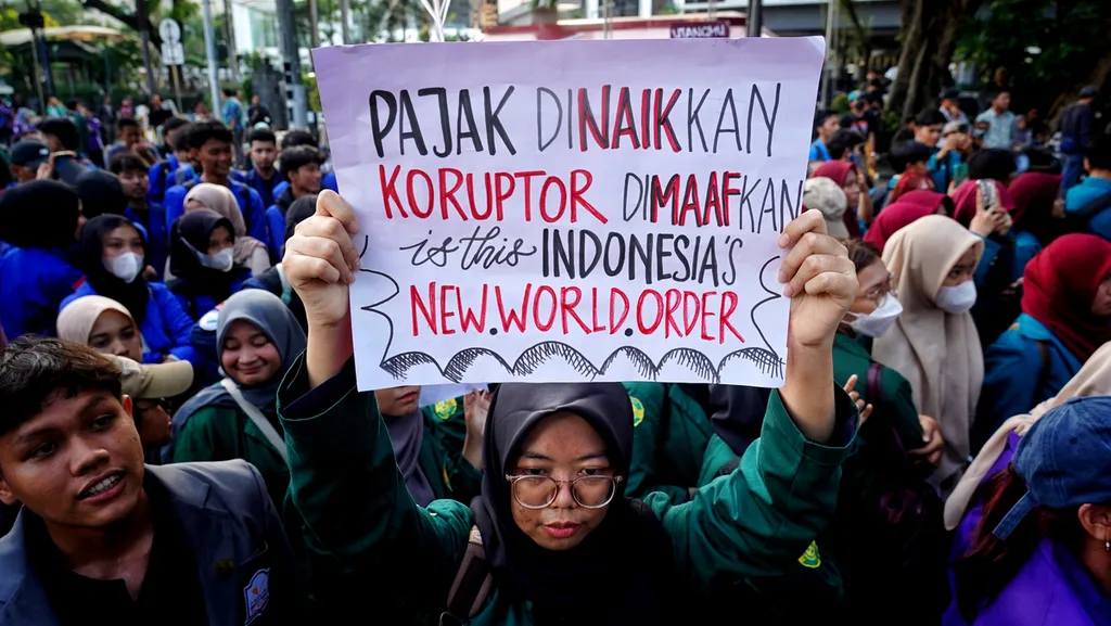 Salah satu poster protes yang dibawa para mahasiswa dari gabungan BEM Seluruh Indonesia saat menggelar aksi penolakan kenaikan Pajak Pendapatan Negara di sekitar kawasan Patung Arjuna Wijaya, Jakarta, Jumat (27/12/2024). Gelombang aksi menolak rencana pemerintah menaikkan PPN menjadi 12 persen terus digelar. Kenaikan PPN menjadi 12 persen ini dianggap membebani rakyat Indonesia. Para mahasiswa menilai pemerintah semakin tidak memihak kepada rakyat yang dibebani pajak berlebih. Selain itu, alokasi pajak yang hanya untuk kepentingan anggarwn pemerintah. Kenaikan PPN hingga 12 persen juga dipandang akan berdampak pada pelemahan ekonomi masyarakat, khususnya masyarakat kelas menengah kebawah. KOMPAS/RONY ARIYANTO NUGROHO 27-12-2024
