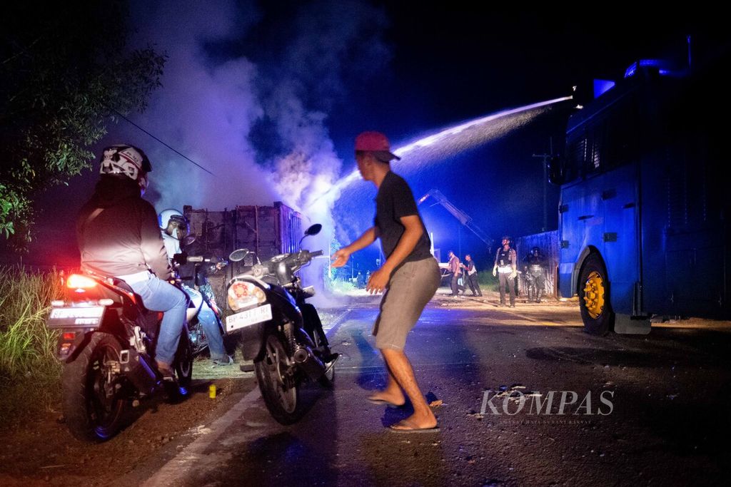 Aparat memadamkan kontainer yang dibakar dan digunakan warga untuk menghalangi laju aparat gabungan saat akan mengamankan pematokan dan pengukuran lahan di Pulau Rempang, Batam, Kepulauan Riau, Kamis (7/9/2023).