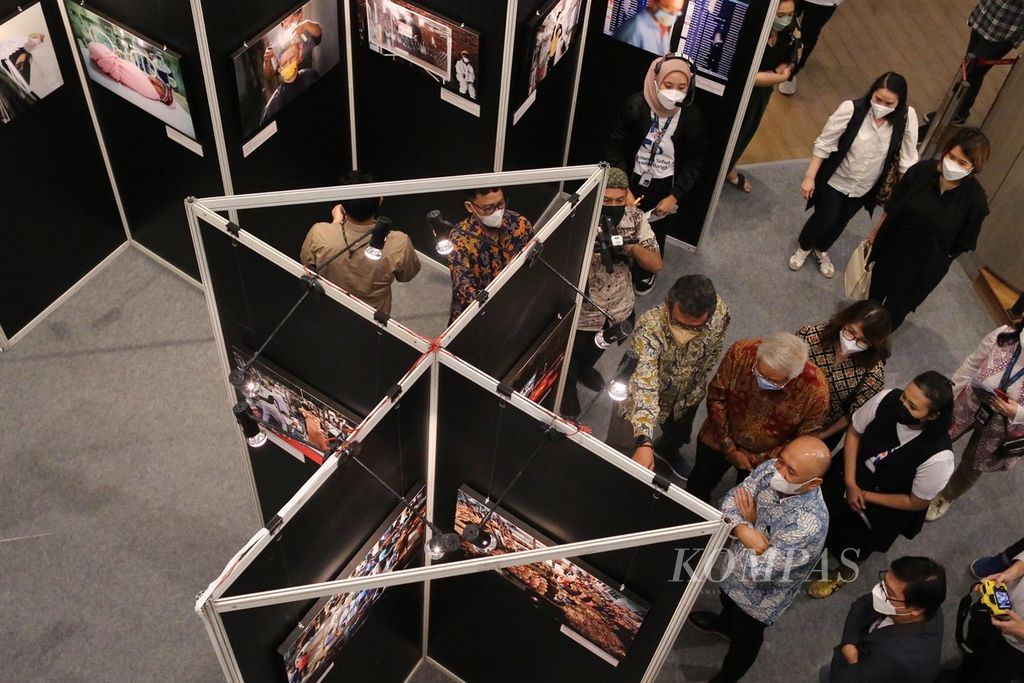 Menteri Koperasi dan UKM Teten Masduki menikmati foto-foto yang dihadirkan usai membuka pameran foto yang bertajuk 'Indonesia Sehat, Ekonomi Bangkit' di Neo Soho Mall, Jakarta, Rabu (13/4/2022). Pameran yang menghadirkan 50 foto karya pewarta foto Kontan dan finalis lomba foto ini akan berlangsung hingga 17 April. 