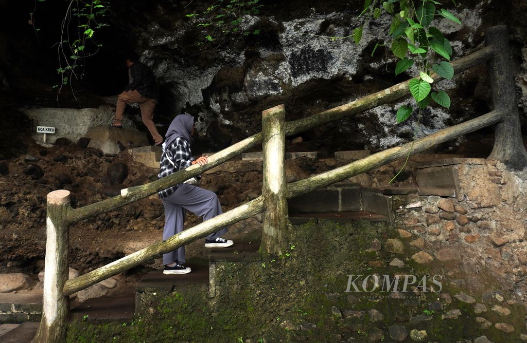 Dua wisatawan berjalan memasuki Goa Kreo, Kecamatan Gunungpati, Kota Semarang, Jawa Tengah, Minggu (29/12/2024). Goa dengan tinggi 2,5 meter dan kedalaman 8 meter itu dipercaya merupakan salah satu tempat Sunan Kalijaga bertafakur di tengah perjalanan membawa kayu jati untuk tiang utama Masjid Agung Demak. Selama bertafakur, ada empat sosok monyet yang menghampiri dan menawarkan bantuan kepada Sunan Kalijaga. 