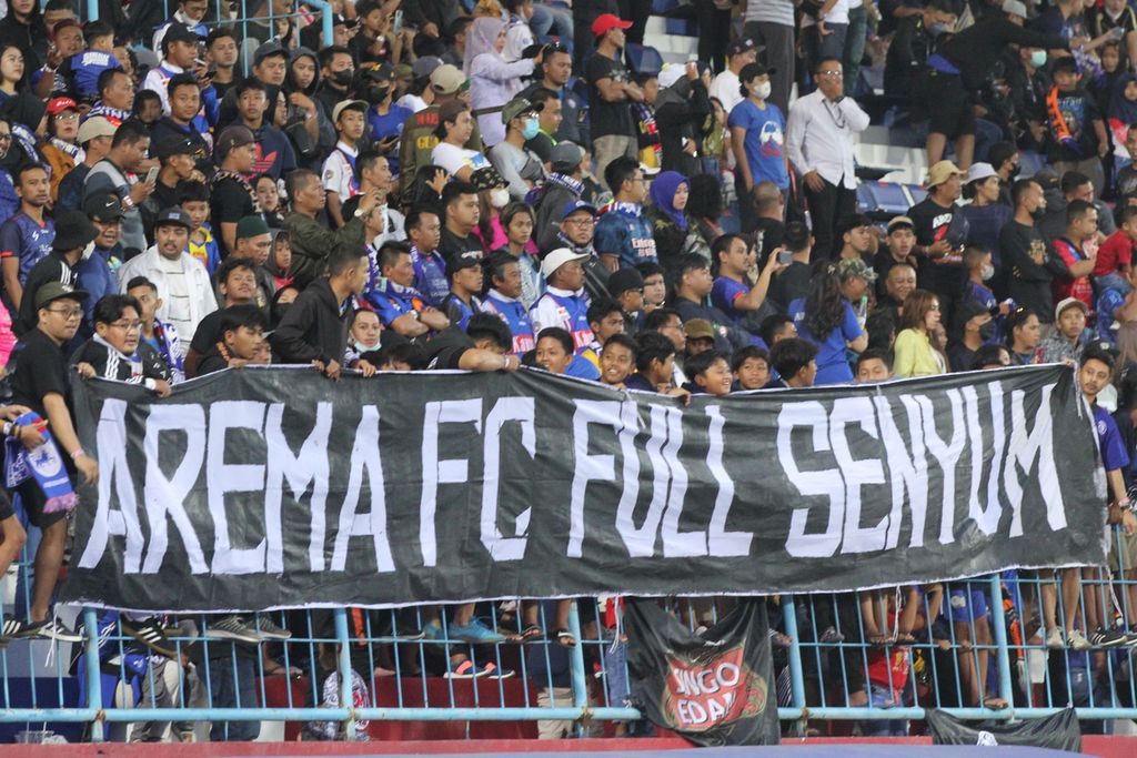Suporter Arema FC, Aremania, membentangkan spanduk dukungan kepada klub kesayangan mereka saat menghadapi PSIS Semarang dalam laga pertemuan kedua semifinal Piala Presiden di Stadion Kanjuruhan, Malang, Jawa Timur, Senin (11/7/2022). Arema FC lantas ke final dan menjadi juara turnamen pramusim itu.