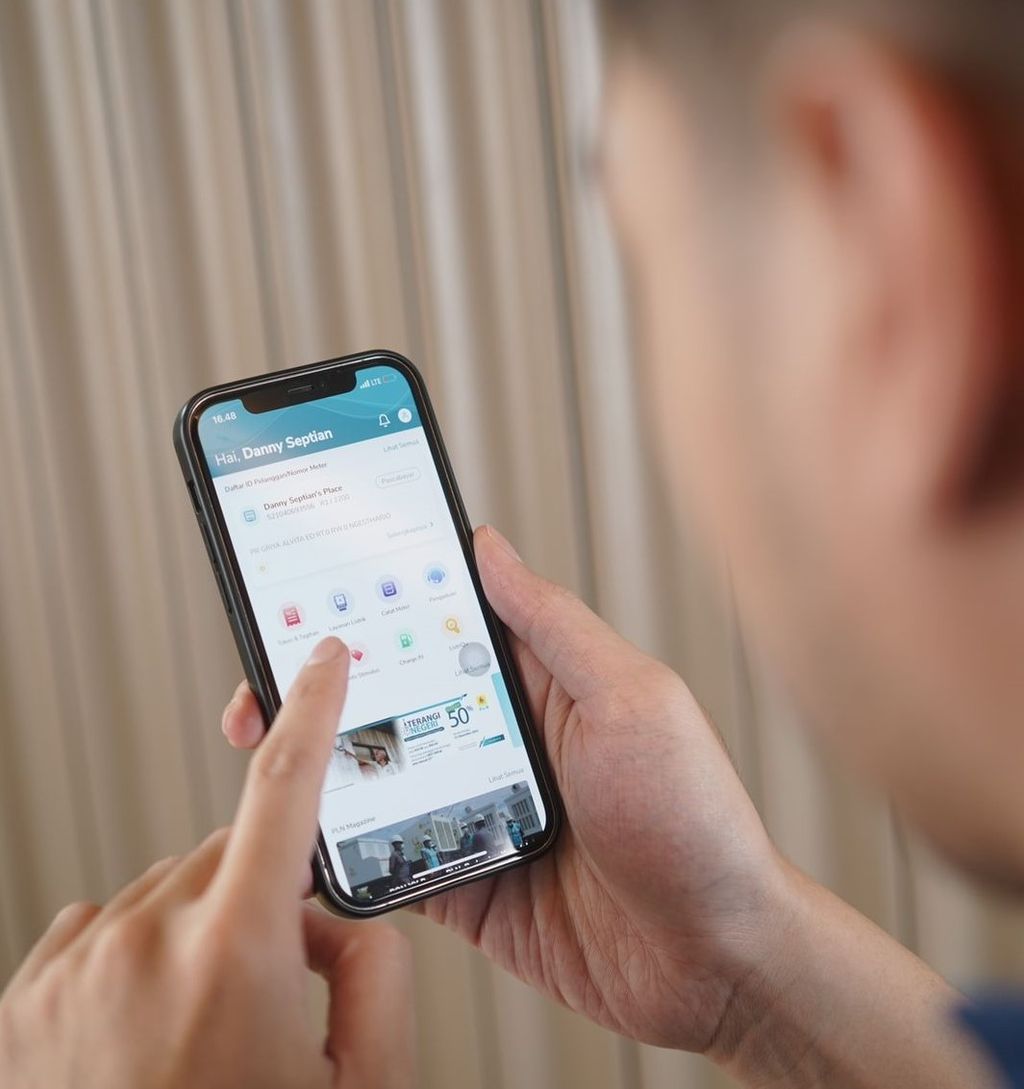 Seorang petugas PLN memperlihatkan penggunaan PLN Mobile di kalangan pelanggan di NTT.