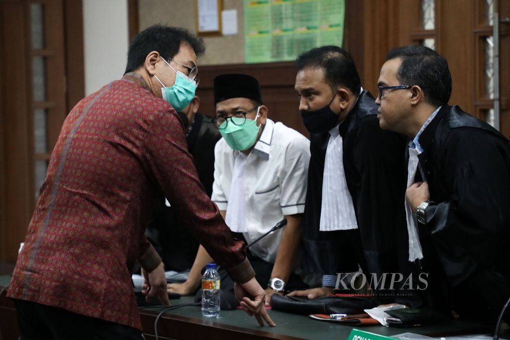 Bekas Wakil Ketua DPR, Azis Syamsuddin, berbincang dengan penasihat hukumnya seusai persidangan dengan agenda pembacaan dakwaan di Pengadilan Tindak Pidana Korupsi (Tipikor), Jakarta, Senin (6/12/2021). 