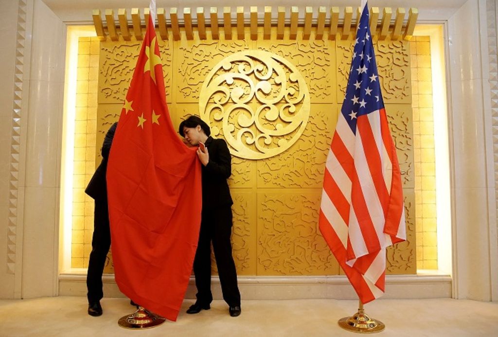 Staf Kementerian Transportasi China menyiapkan bendera China dan AS untuk pertemuan antara Menteri Transportasi China Li Xiaopeng dan Menteri Transportasi AS Elaine Chao di Kementerian Transportasi China di Beijing, China, 27 April 2018. Relasi perdagangan antara China dan AS saat ini diwarnai ketegangan akibat kebijakan peningkatan bea impor oleh AS atas sejumlah produk China.