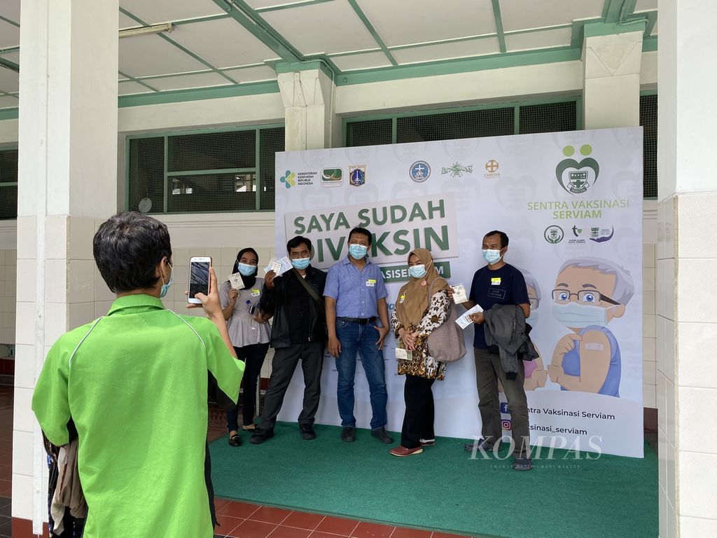 Sejumlah warga berfoto seusai melaksanakan vaksinasi di Sentra Vaksinasi Serviam yang berada di Sekolah Santa Ursula, Jakarta, Kamis (6/5/2021). Sentra Vaksinasi Serviam yang digagas oleh alumni sekolah Katolik itu melayani vaksinasi untuk warga DKI Jakarta lintas agama.