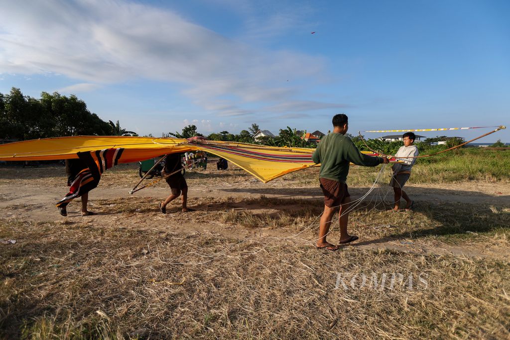 Membawa layang-layang raksasa.