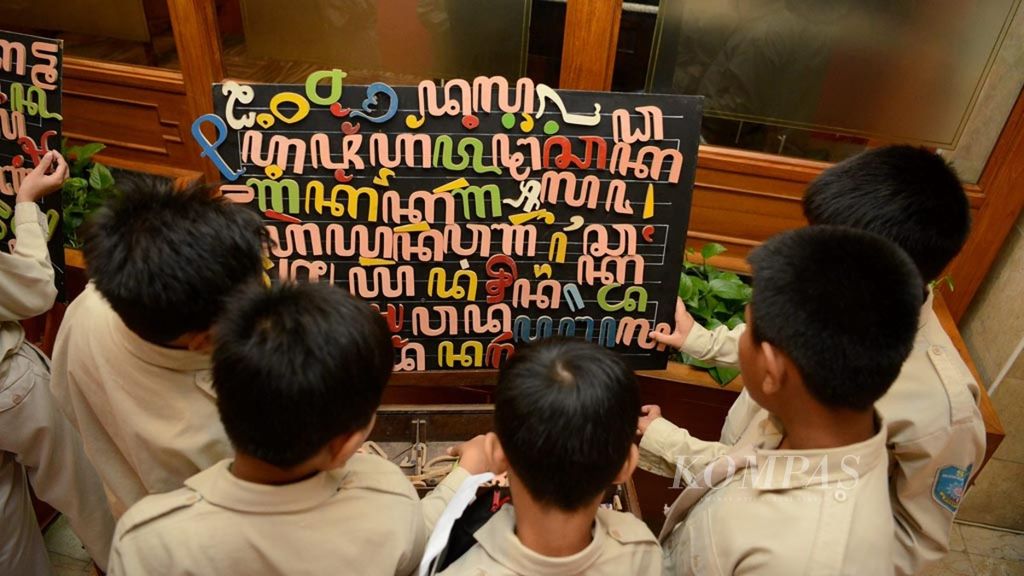 Pelajar menggunakan alat edukasi aksara Jawa yang dipamerkan saat kegiatan Kongres Bahasa Java VI di Hotel Inna Garuda, Yogyakarta, awal November 2016. Kongres itu diselenggarakan setiap lima tahun sekali untuk membahas perihal bahasa dan budaya Jawa. 