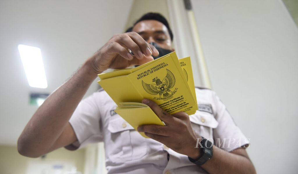 Petugas memanggil nama penerima vaksin meningitis melalui buku vaksin meningitis di Pelayanan Vaksinasi Internasional Kantor Kesehatan Pelabuhan Kelas I Surabaya di Kabupaten Sidoarjo, Jawa Timur, Senin (28/11/2022). Sejak 11 November 2022, Kementerian Kesehatan menetapkan bahwa vaksin meningitis tidak lagi menjadi syarat wajib bagi calon jemaah yang akan melakukan umrah. Vaksin meningitis hanya diwajibkan untuk calon jemaah haji. Walau demikian sebagai perlindungan diri banyak calon jemaah umrah berinisiatif tetap melakukan vaksinasi meningitis. Kompas/Bahana Patria Gupta (BAH)