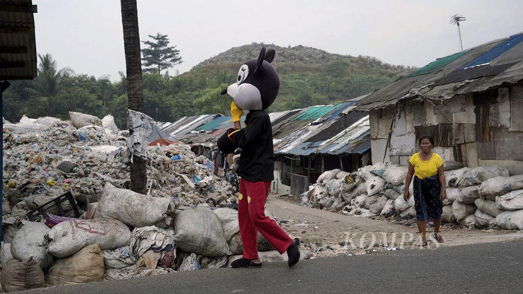 Badut melintas di hunian pemulung di sekitar Tempat Pengelolaan Sampah Terpadu (TPST) Bantar Gebang, Kota Bekasi, Jawa Barat, Kamis (2/7/2020). 