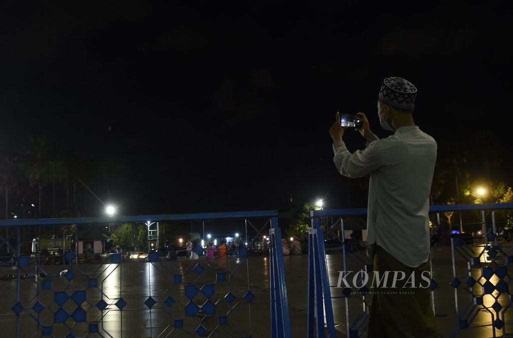 Warga berusaha memotret bulan dengan telepon seluler seusai menjalani ibadah shalat Gerhana Bulan di Masjid Nasional Al Akbar, Surabaya, Jawa Timur, Minggu (26/5/2021). Gerhana bulan terjadi saat sebagian atau keseluruhan penampang Bulan tertutup oleh bayangan Bumi. Itu terjadi apabila Bumi berada di antara Matahari dan Bulan pada satu garis lurus yang sama sehingga sinar Matahari tidak dapat mencapai Bulan karena terhalangi oleh Bumi. 