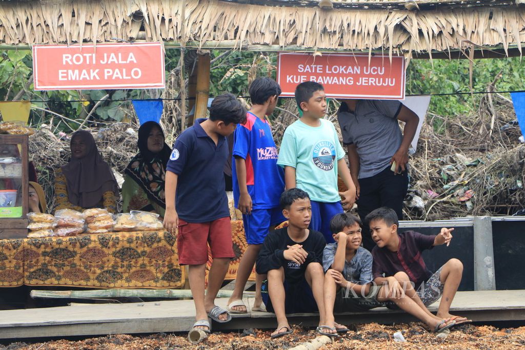 Anak-anak pesisir menonton Festival Payau Puan Paloh di Kelurahan Paya Pasir, Medan, Sumatera Utara, Sabtu (11/3/2023). Para perempuan pesisir menampilkan teater, puisi, dan bernyanyi dalam festival itu. 