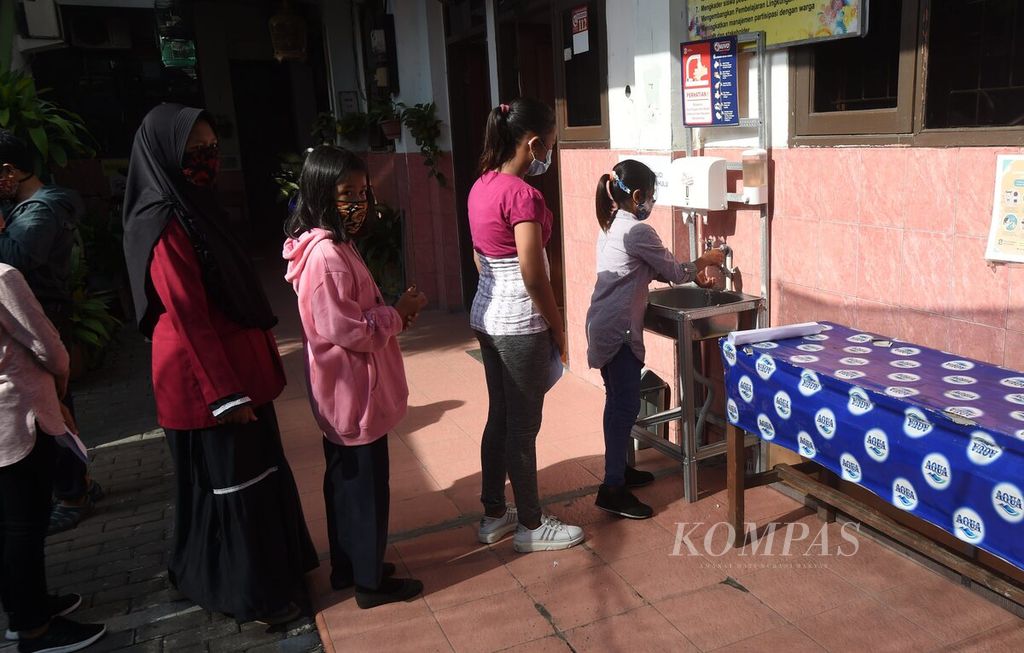 Siswa SD Negeri Kaliasin V antre mencuci tangan setibanya di sekolah saat akan menjalani imunisasi, Surabaya, Jawa Timur, Kamis (15/10/2020). 
