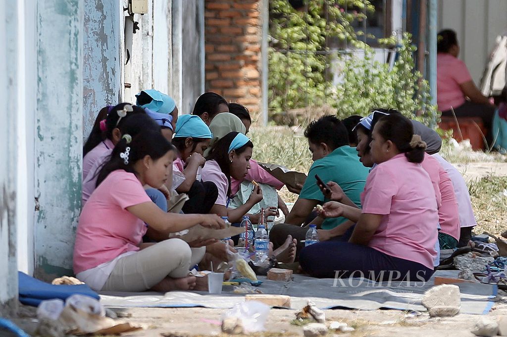 Buruh makan siang bersama saat jam istirahat di Kawasan Berikat Nusantara, Cilincing, Jakarta Utara, Kamis (3/9/2015).  