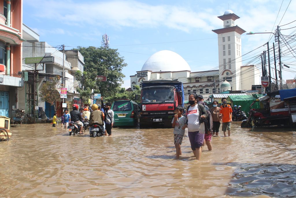 Sejumlah warga berjalan kaki melintasi Jalan Raya Dayeuhkolot, Kabupaten Bandung, Jawa Barat, Senin (14/3/2022).