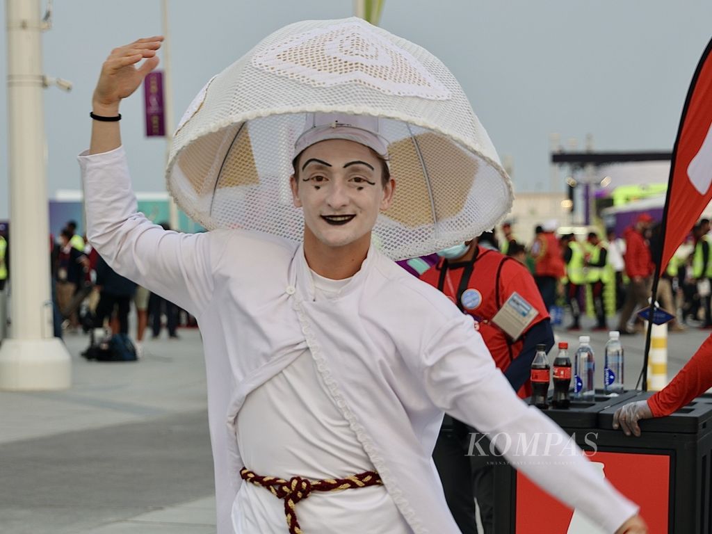 Seorang pengisi acara menari untuk menghibur penggemar sepak bola sebelum laga Portugal versus Maroko di Stadion Al Thumama, Doha, Sabtu (10/12/2022). Fitur otofokus di EOS R6 membantu menghadirkan foto dengan obyek secara optimal.