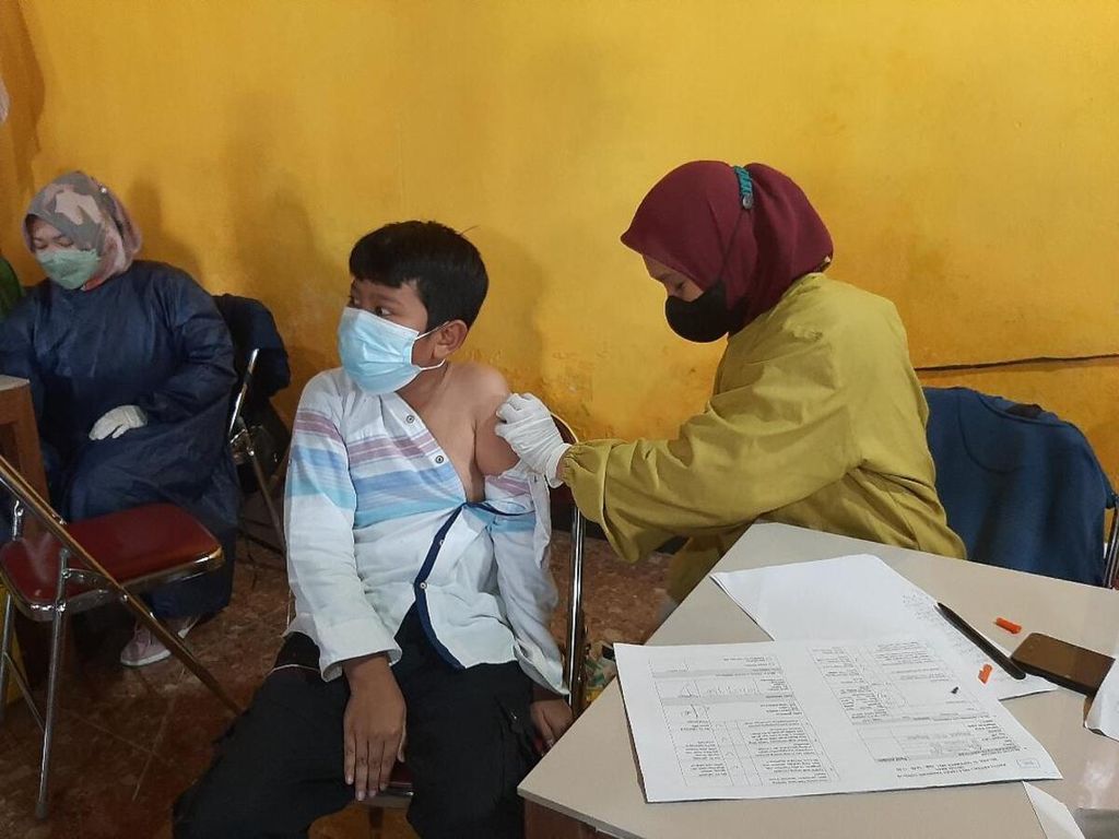 Serang siswa SD mendapatkan suntikan vaksinasi dosis pertama di Balai Desa Banyusidi, Kecamatan Pakis, Kabupaten Magelang, Jawa Tengah, Selasa (11/1/2022).