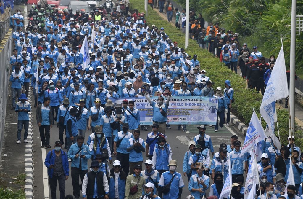 Massa buruh dari berbagai serikat pekerja berjalan kaki menuju Gedung DPR/MPR, Jakarta, untuk mengikuti unjuk rasa, Rabu (15/6/2022). Dalam aksi yang diikuti ribuan buruh tersebut mereka kembali menyerukan penolakan atas revisi UU Pembentukan Peraturan Perundang-undangan (UU P3) dan penolakan UU Cipta Kerja. Para buruh juga menyerukan akan melakukan mogok kerja nasional jika DPR tidak mencabut revisi UU P3. 
