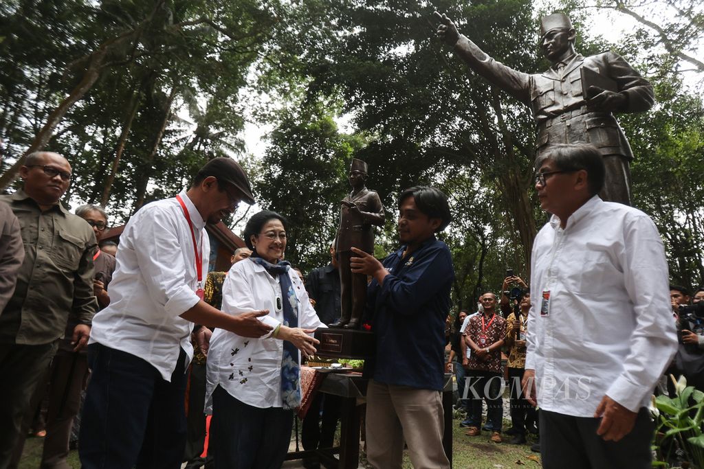 Presiden ke-5 RI Megawati Soekarnoputri didampingi wartawan senior Sindhunata (kanan) menerima miniatur patung Bung Karno dari pematung Dunadi (kiri) saat acara peresmian patung Bung Karno di Omah Petroek, Desa Hargobinangun, Pakem, Sleman, DI Yogyakarta, Rabu (23/8/2023). Patung setinggi 6 meter karya pematung Dunadi itu diletakkan di atas batu dari Gunung Merapi yang menjadi simbol kekokohan dan keabadian Pancasila.