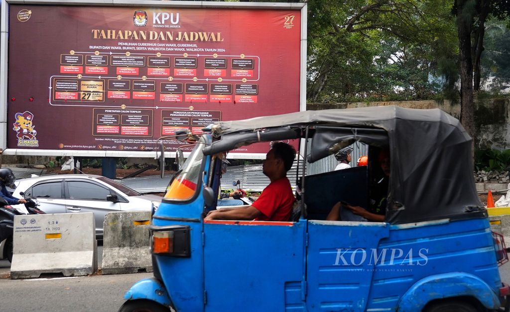 Warga melintasi reklame sosialisasi tahapan pelaksanaan pilkada serentak 2024 yang terpasang di kawasan Dukuh Atas, Jakarta, Kamis (1/8/2024). 