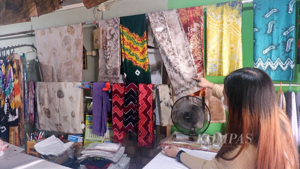Calon pembeli melihat kain sasirangan di toko Katuju Sasirangan yang berada di Kampung Sasirangan, Jalan Seberang Mesjid, Kelurahan Seberang Mesjid, Kecamatan Banjarmasin Tengah, Kota Banjarmasin, Kalimantan Selatan, Rabu (21/9/2022). Kampung Sasirangan adalah sentra perajin dan penjualan kain sasirangan di Banjarmasin.