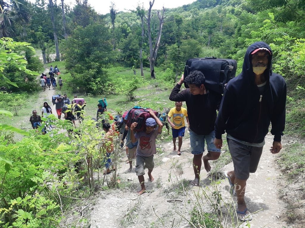Warga berjalan kaki melewati jalan setapak yang terjal lantaran terjadi longsor di ruas Jalan Timor Raya, tepatnya di Kelurahan Takari, Kabupaten Kupang, Nusa Tenggara Timur, pada Minggu (19/2/2022). Longsor terjadi sejak Jumat (18/2/2023) malam.