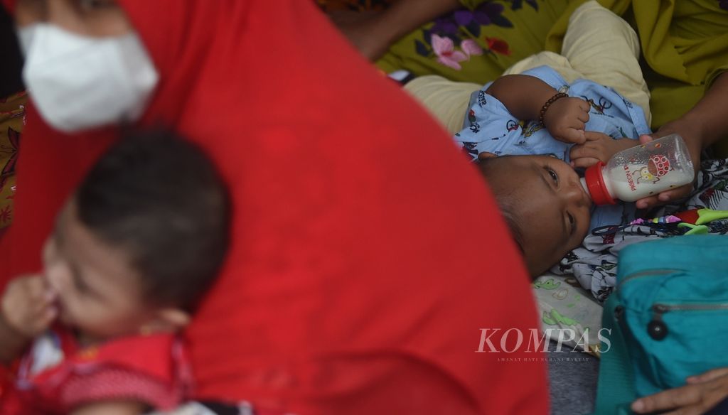 Bayi minum dengan botol saat peluncuran Gebyar Lomba Balita Sehat di halaman Balai Kota Surabaya, Jawa Timur, Rabu (26/1/2022). Lomba yang akan berlangsung selama satu bulan untuk mewujudkan Kota Surabaya EMAS (Eleminasi Masalah Stunting). Selain melihat kondisi kesehatan dari anak, juga dilihat bagaimana ibu menyiapkan makanan pendamping yang bergizi.