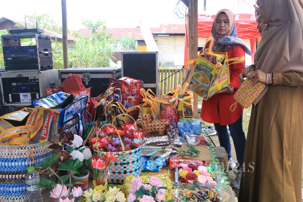 Pengunjung melihat hasil kerajinan tangan yang dibuat dari sampah plastik pada acara Apresiasi dan Pertemuan Tahunan Bank Sampah, di Medan, Sumatera Utara, Selasa (24/1/2023). Pemilahan dan pengelolaan sampah sejak di rumah harus dilakukan untuk mengurangi sampah yang berakhir di tempat pembuangan akhir. 