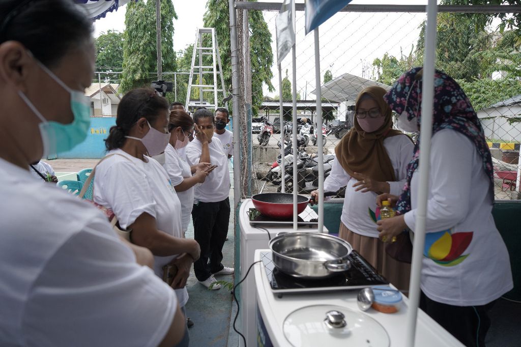 Kelompok ibu-ibu penerima kompor induksi sedang mencoba memasak dengan kompor induksi PLN.