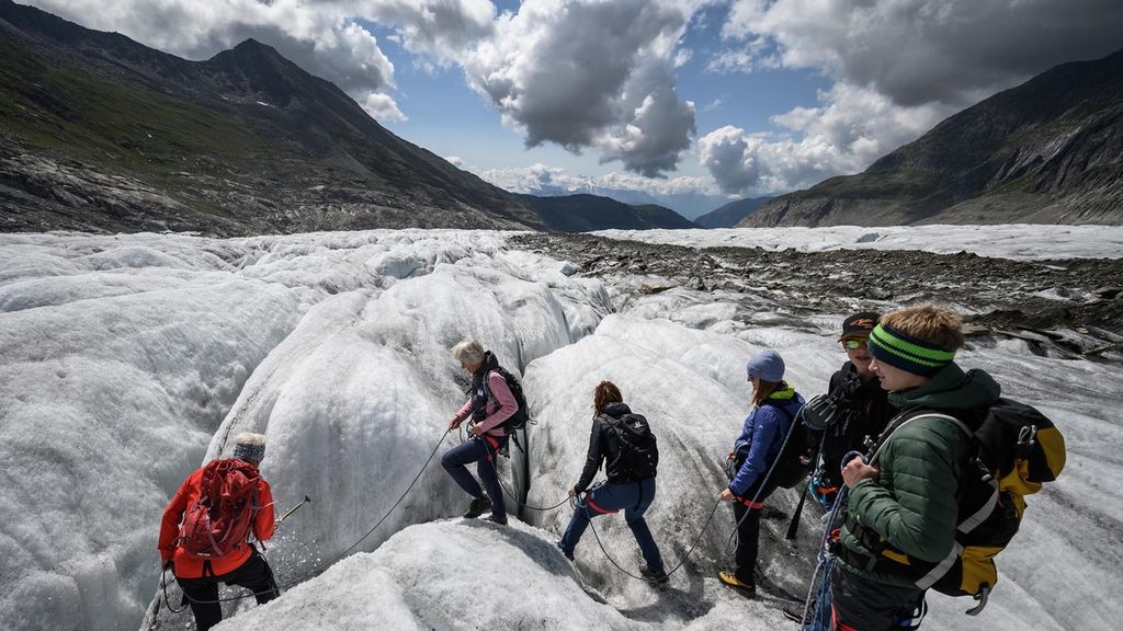 Remaja berjalan di atas Gletser Aletsch saat menemani ahli glasiologi Swiss, Matthias Huss, melakukan pengukuran terhadap ketinggian gletser terluas di Swiss tersebut. Menurut Huss, gletser seperti termometer raksasa yang menunjukkan kenaikan suhu melalui mencairnya es dan menyusutnya volume.