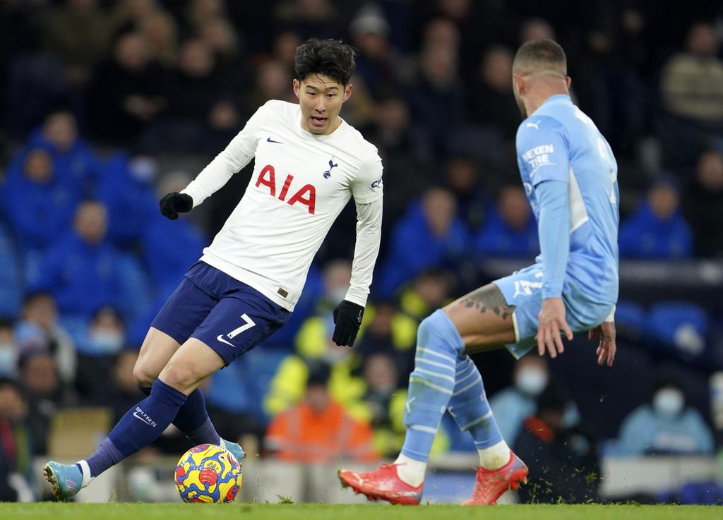 Pemain Tottenham Hotspur, Song Heung-min (kiri), berebut bola dengan pemain Manchester City, Kyle Walker, dalam pertandingan Liga Inggris di Stadion Etihad, Manchester, Minggu (20/2/2022) dini hari WIB.