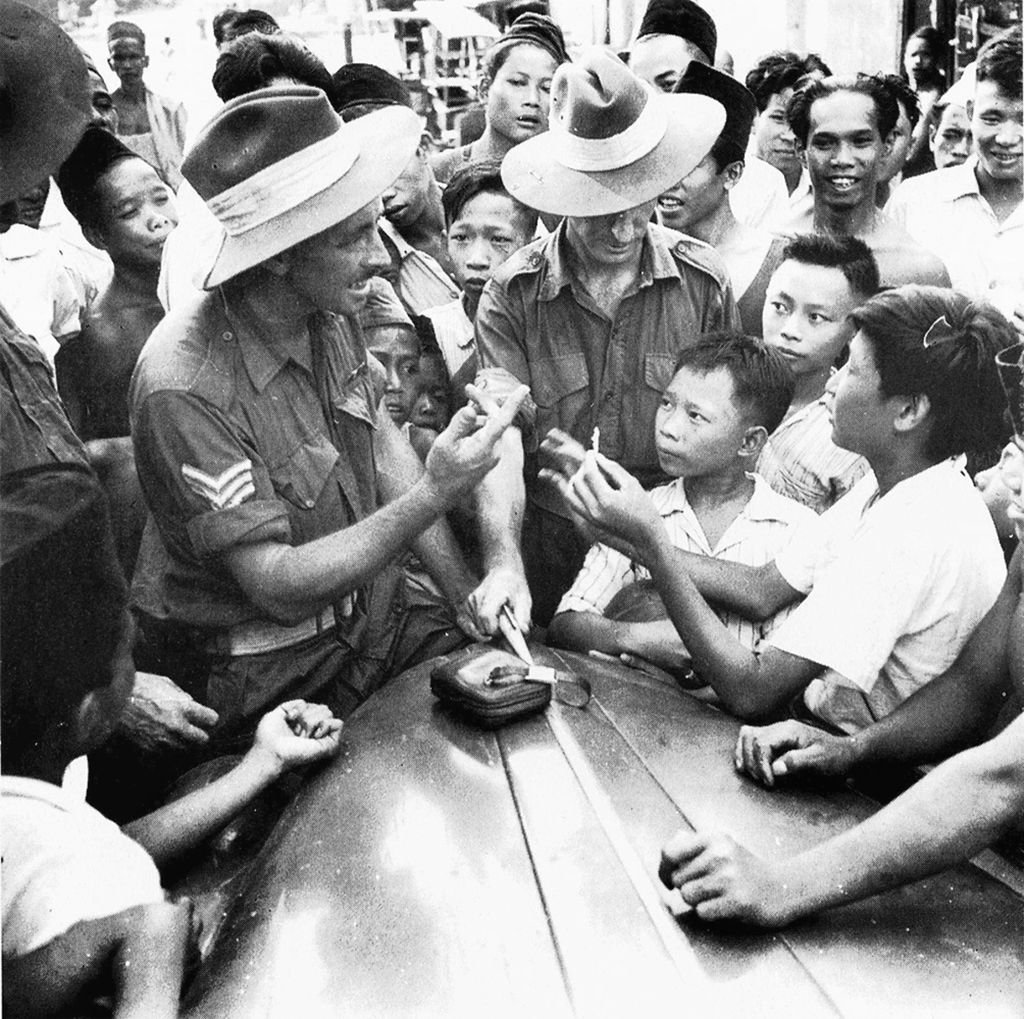 Sepasang serdadu Australia (Australia Imperial Forces-AIF) bercengkrama dengan masyarakat Kota Makassar tahun 1945. Masyarakat Indonesia berhubungan baik dengan serdadu Australia karena menyadari dukungan publik Australia terhadap kemerdekaan Indonesia. (Sumber: Australia War Memorial)