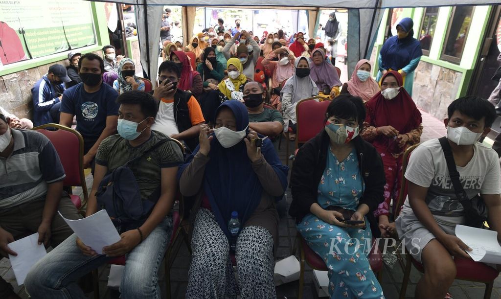 Warga tetap mengenakan masker saat antre mengambil bantuan langsung tunai (BLT) minyak goreng di Markas Koramil 05 Kebon Jeruk, Jakarta Barat, Kamis (19/5/2022). Bantuan berupa uang tunai sebesar Rp 300.000 itu diharapkan dapat meringankan beban ekonomi bagi keluarga penerima manfaat.