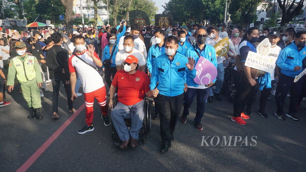 Presiden APSF Osoth Bhavilai (kelima dari kanan) menggandeng Ketua Umum NPC Indonesia Senny Marbun (merah) dalam kirab sosialisasi ASEAN Para Games 2022 pada hari bebas kendaraan bermotor, di Jalan Slamet Riyadi, Kota Surakarta, Jawa Tengah, Minggu (3/7/2022). Kirab itu diikuti pula oleh Ketua Panitia Penyelenggara ASEAN Para Games Gibran Rakabuming Raka dan para atlet difabel dari kontingen Indonesia. 