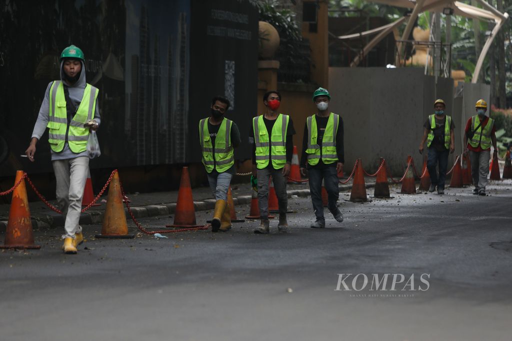 Pekerja meninggalkan lokasi proyek pembangunan sarana transportasi umum di Setiabudi, Jakarta, Selasa (22/2/2022). Setelah mendapat penolakan kuat dari publik, khususnya kelompok buruh, pemerintah memutuskan untuk merevisi aturan baru Jaminan Hari Tua dan menunda peluncuran program Jaminan Kehilangan Pekerjaan. Pemerintah juga akan merevisi aturan baru pencairan Jaminan Hari Tua agar tidak menyulitkan masyarakat yang putus kerja di tengah pandemi Covid-19. 