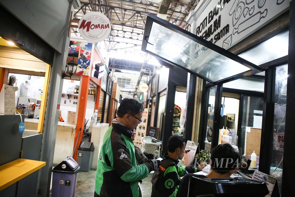 Pengemudi ojek daring memesan makanan untuk pelanggan melalui aplikasi di gerai makanan di pasar Santa, Kebayoran Baru, Jakarta (21/10/2019). Pertumbuhan ekonomi digital dan pengguna internet di Tanah Air turut membantu perkembangan usaha bagi para pelaku UMKM.