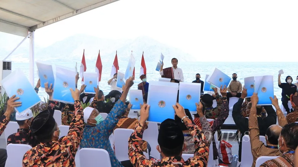Presiden Joko Widodo membagikan Surat Keputusan Penetapan Hutan Adat kepada sejumlah komunitas masyarakat adat kawasan Danau Toba di Desa Simangulampe, Kecamatan Baktiraja, Kabupaten Humbang Hasundutan, Sumatera Utara, Kamis (3/2/2022). Presiden meminta agar hutan adat dimanfaatkan untuk kesejahteraan masyarakat adat.